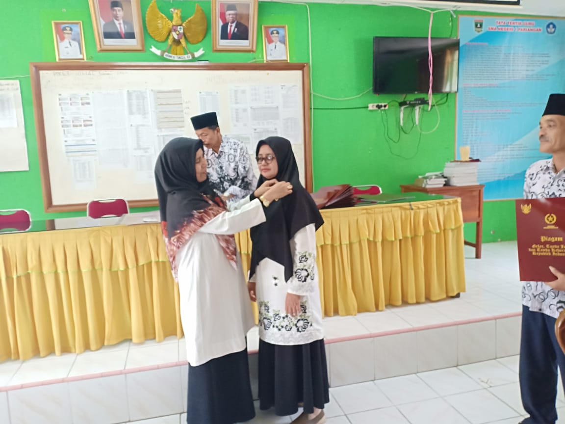 Pemasangan Pin satya lencana kepada Ibuk Emmi Bustami, S.Pd