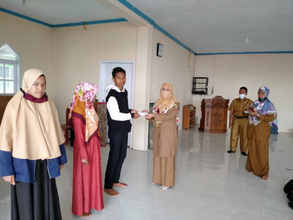 Penyerahan beasiswa oleh kepala sekolah ke pada siswa dan orang tua